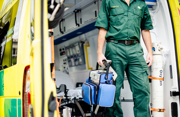 person providing first aid to an unconscious woman on the floor safety training techniques in emergency situations