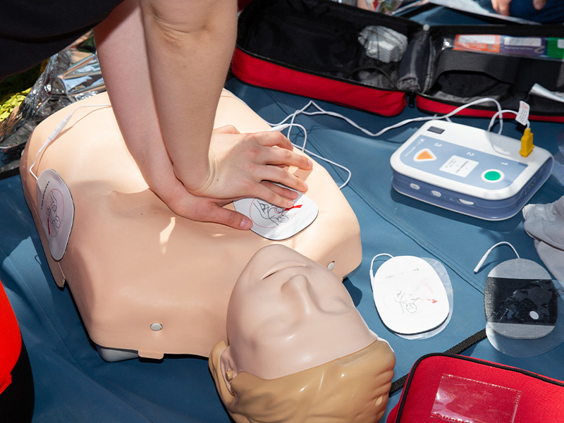 person using an auto-injector device on their thigh to administer medication for severe allergic reactions 2 doses needed